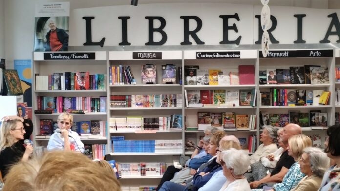 concita con presentatrice con libreria